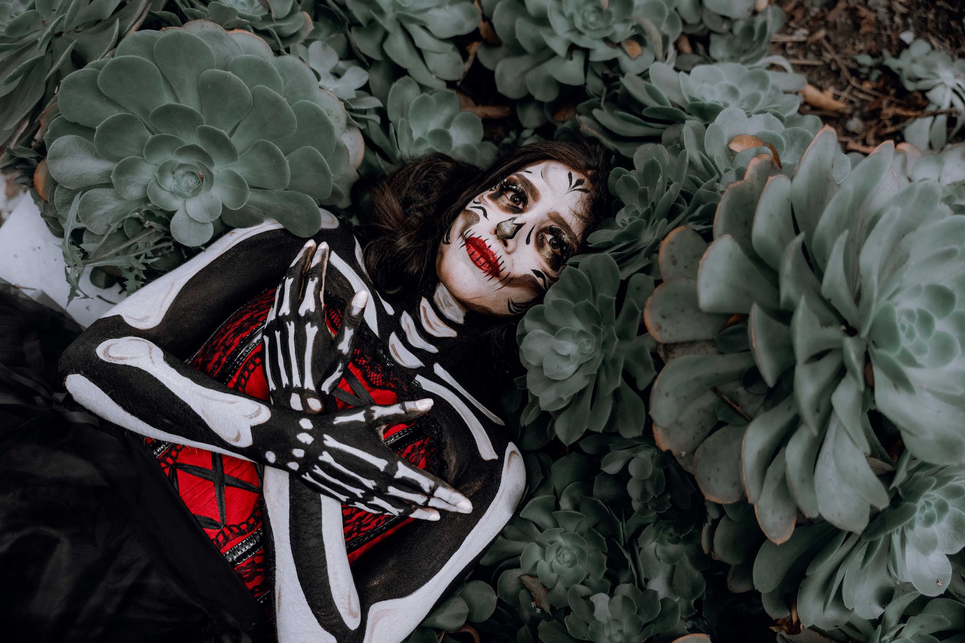 woman wearing halloween costume lying among plants