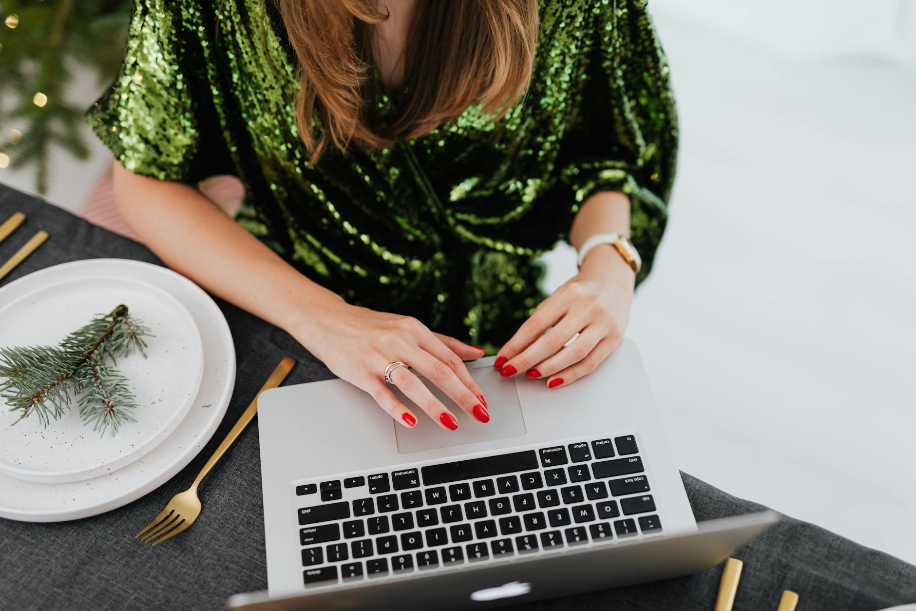 woman with painted nails working by dinner table