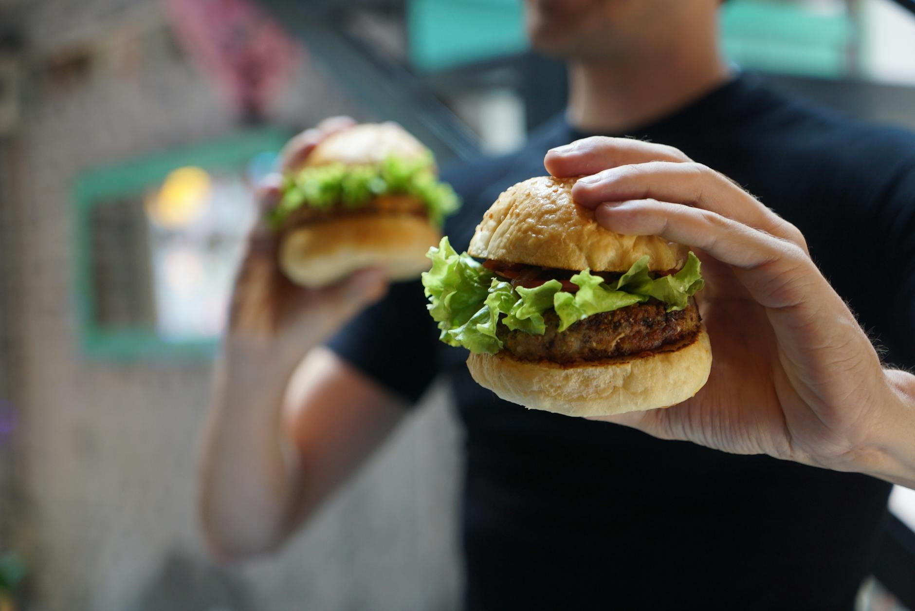 person holding two hamburgers